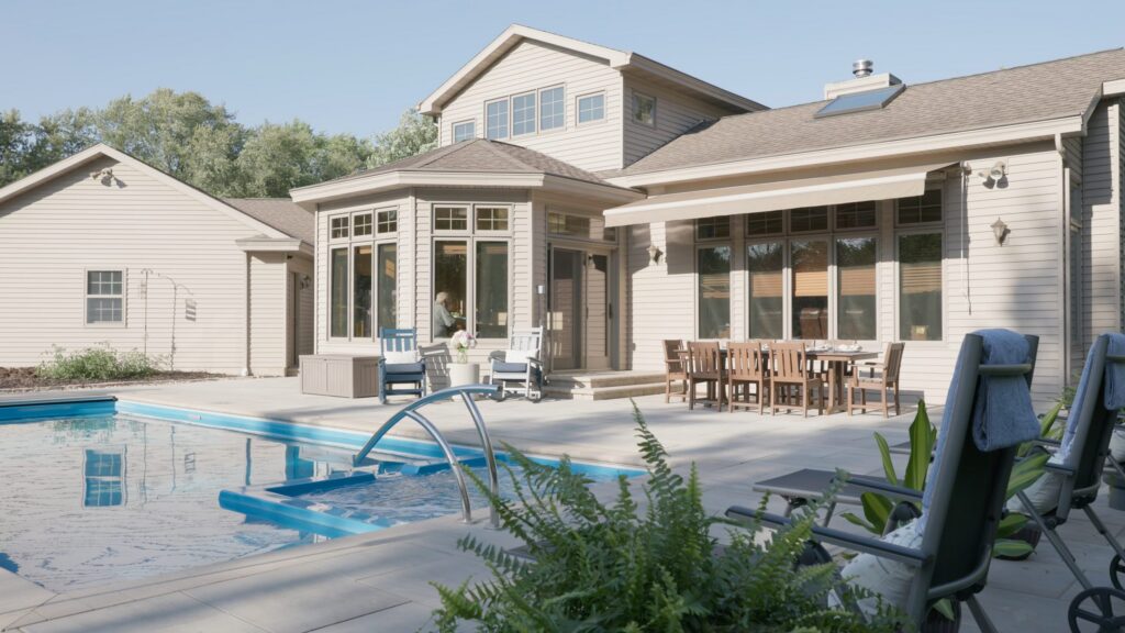 Rear elevation of a Neenah home with a poolside paver patio and covered porch