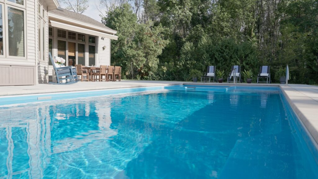 Fiberglass pool water and paver coping with patio seating beyond