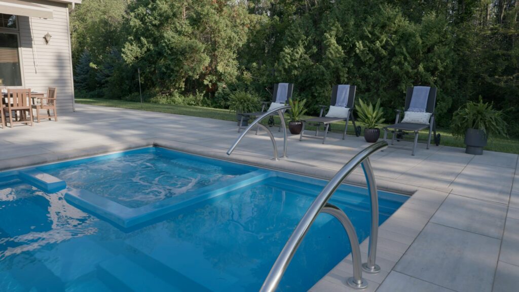 Attached spa with laminar deck jets beside a fiberglass pool