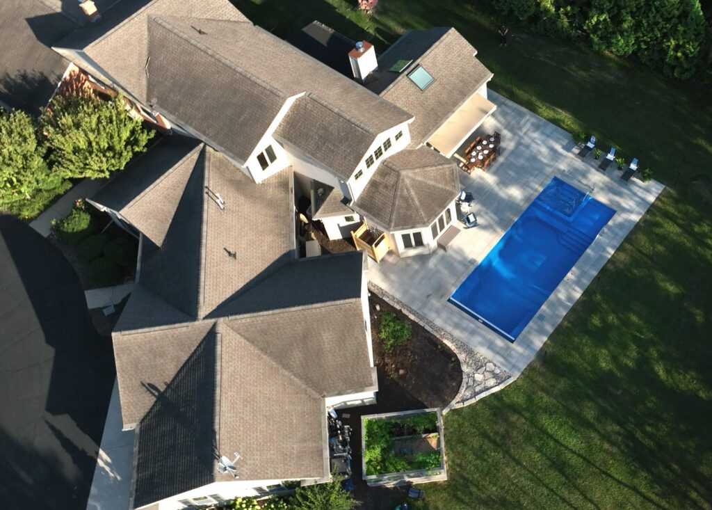Aerial view of a Neenah home with a fiberglass pool and paver patio