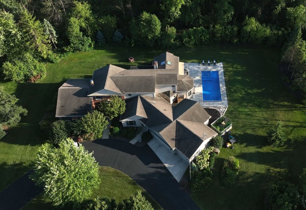 Aerial view of a Neenah property with backyard fiberglass pool and landscaping