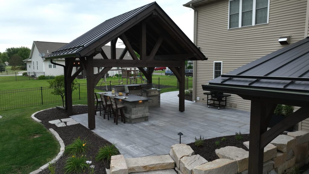 Timber pavilion with a standing seam metal roof beside an attached patio cover