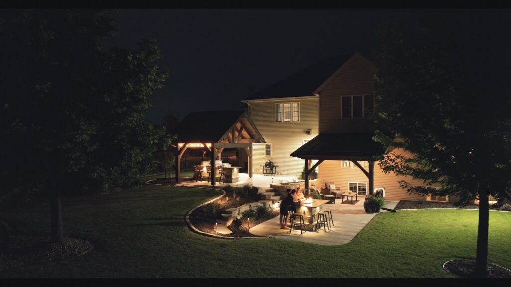 Night exterior of a Neenah home with a lit pavilion and paver patio