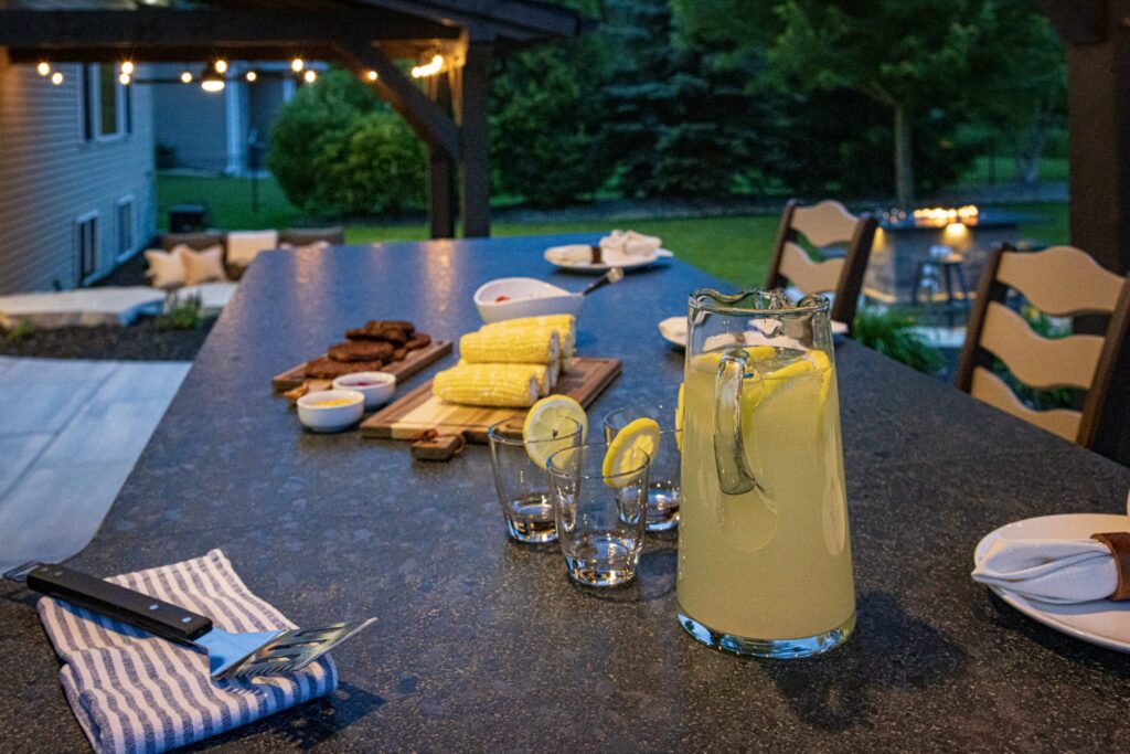 Lemonade and place settings on the outdoor bar top at dusk