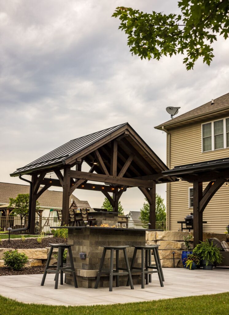Timber pavilion with a black metal roof over the outdoor bar