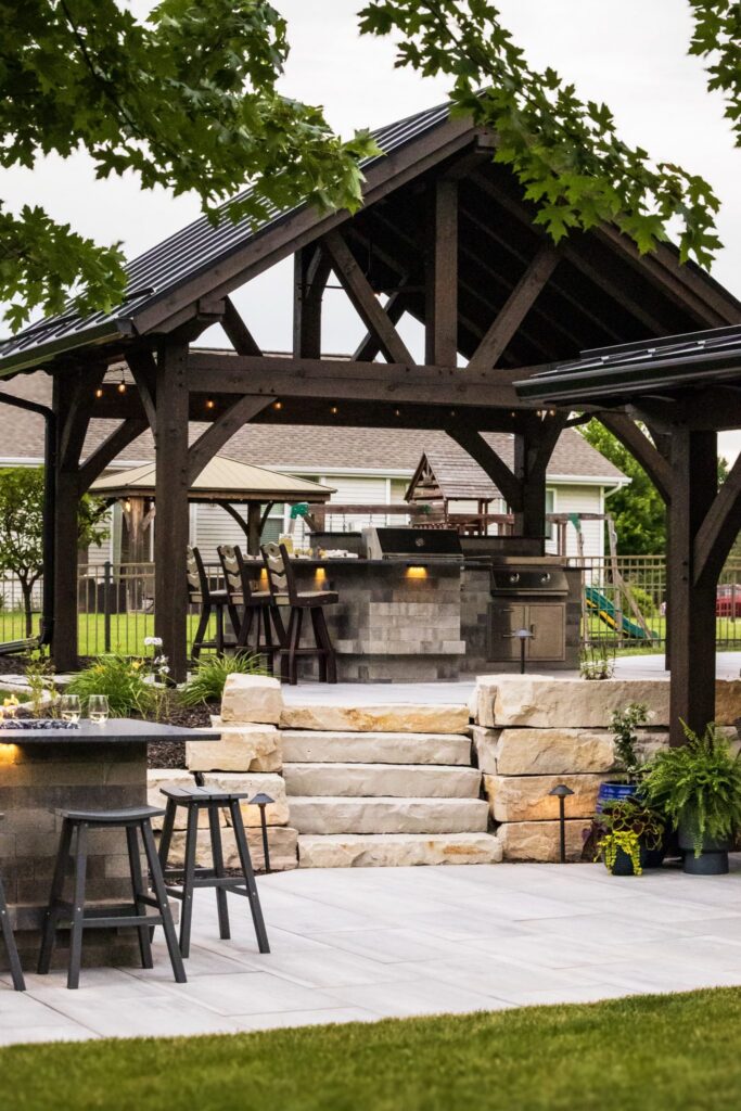 Timber pavilion, outdoor kitchen and natural stone steps between patio levels