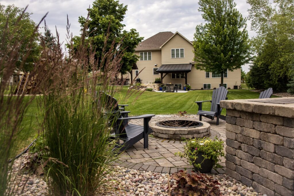 Paver fire pit with Adirondack chairs and a stone seat wall