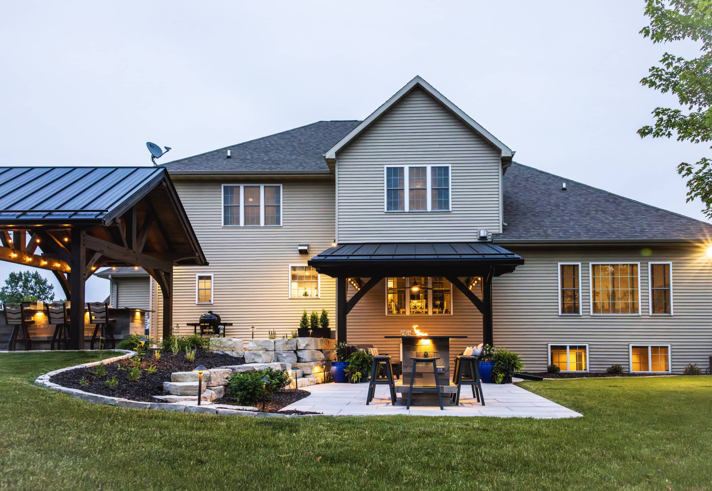 Timber pavilions with black standing-seam metal roofs at the Covered Comfort project in Neenah, Wisconsin